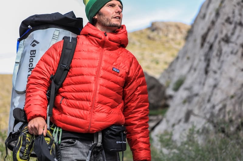 man in red coat hiking mountain