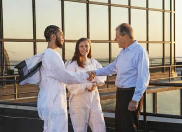 Beekeepers on roof of 53 State St shaking hands with client