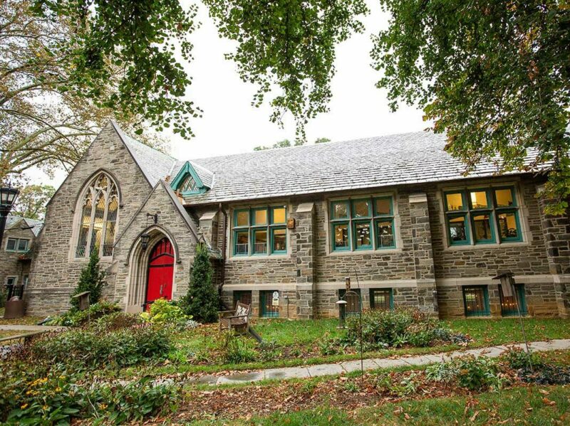 Front of St. James school, with stone walls and a red door