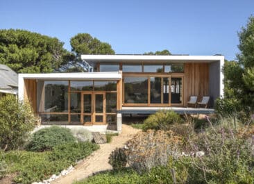 Sustainable design utilizes natural light to heat homes like this glass-walled home surrounded by native plants