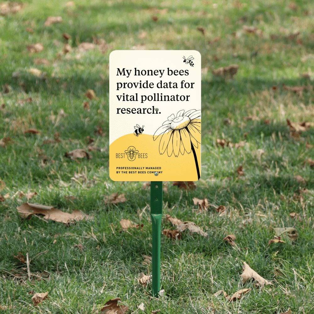 Small metal yard sign that says "my honey bees provide data for vital pollinator research"