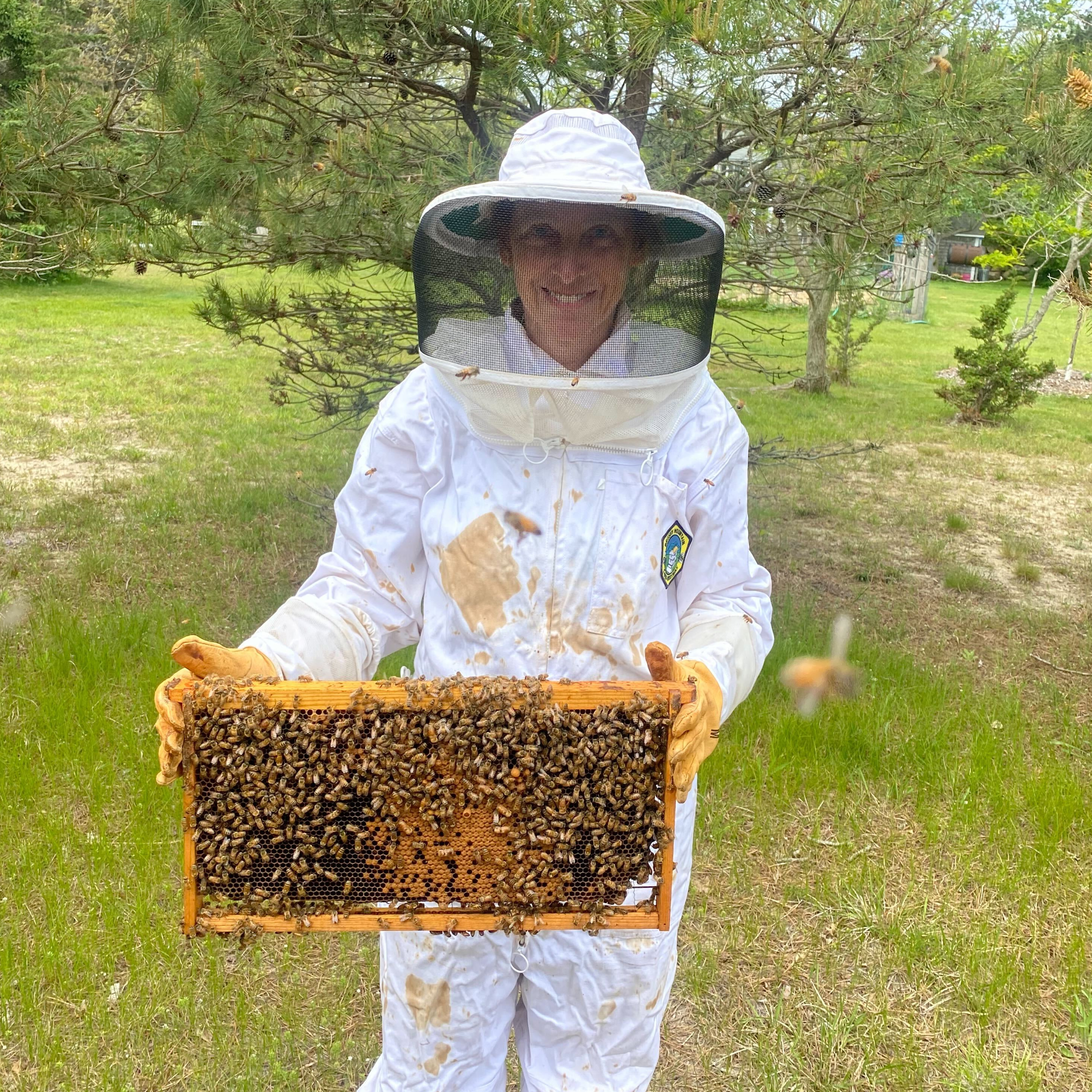 Residential client holding frame of bees